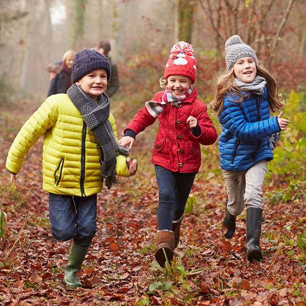 School children running in forest